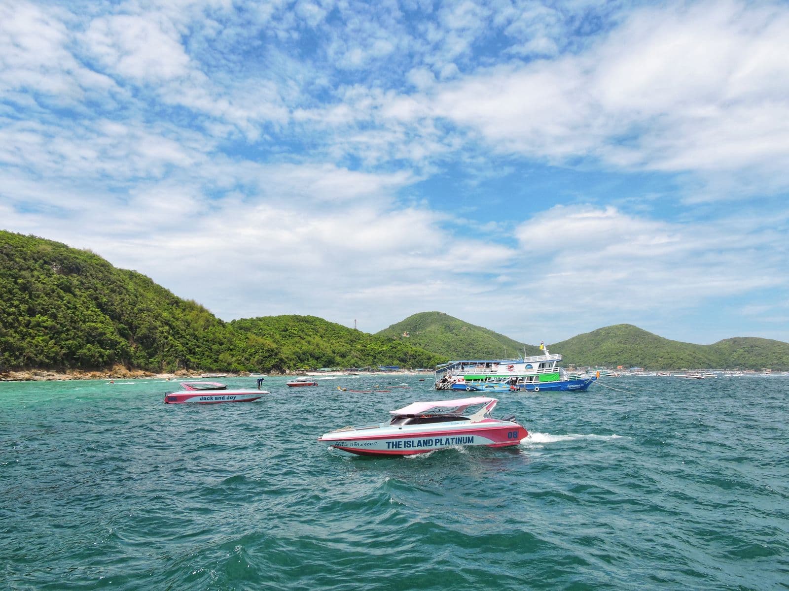 Speedboats off Koh Larn against green hills