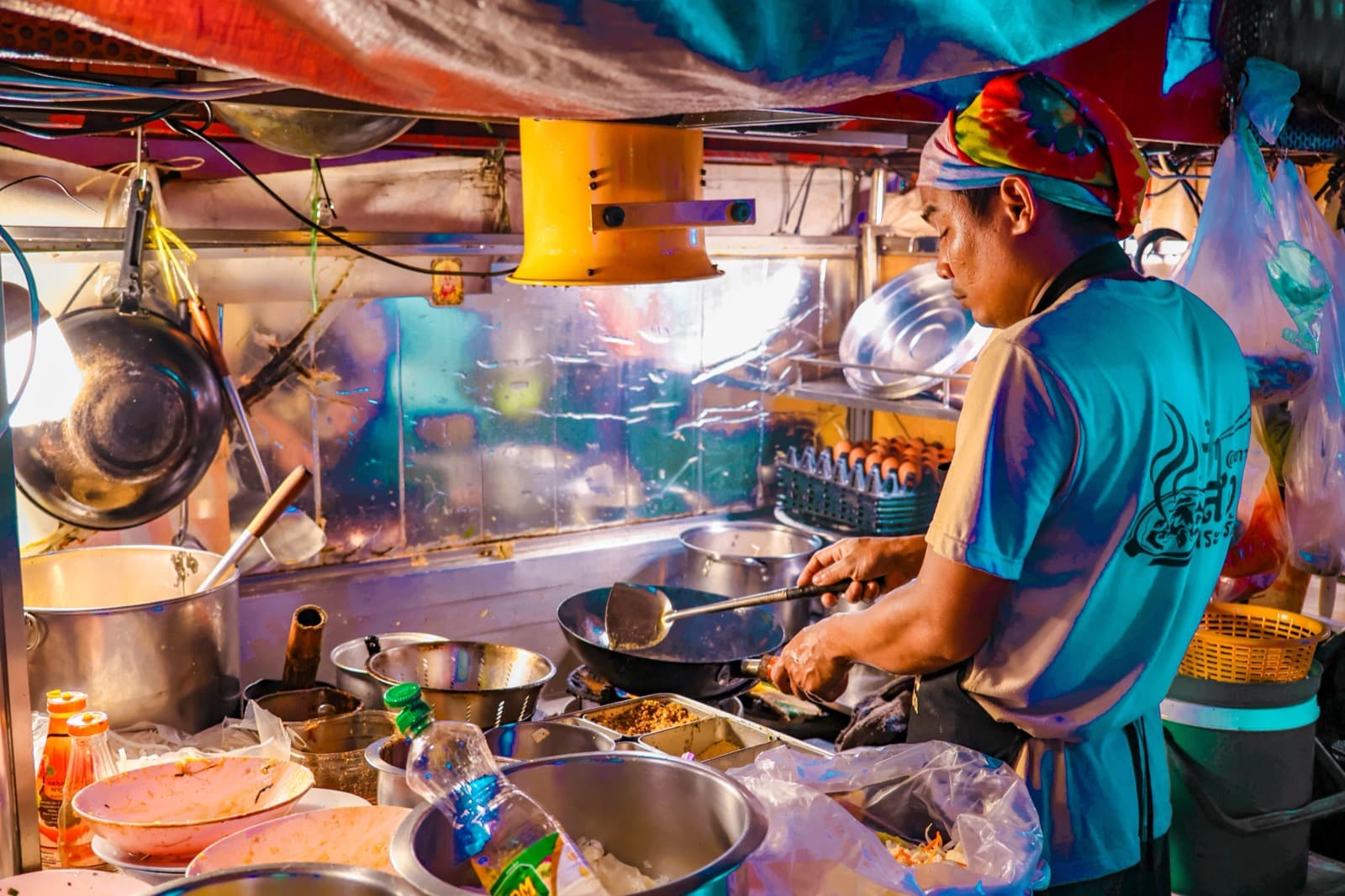 A Thai kitchen with flames leaping around a wok