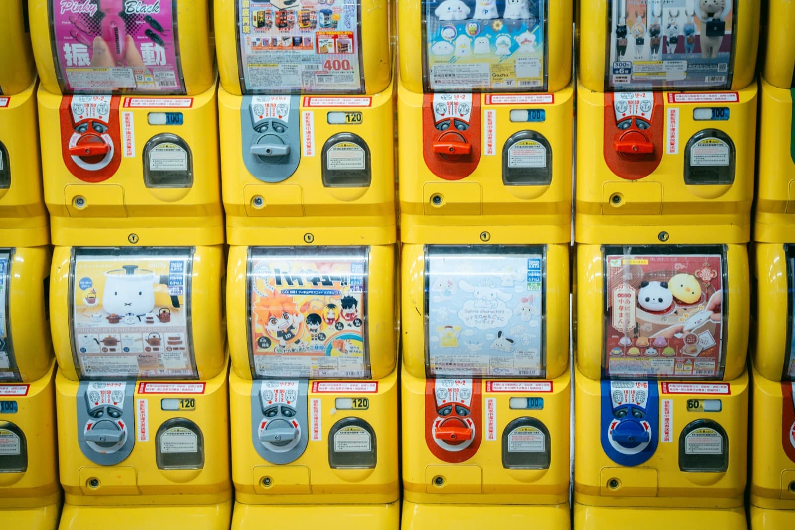 A wall filled top to bottom with capsule toy machines