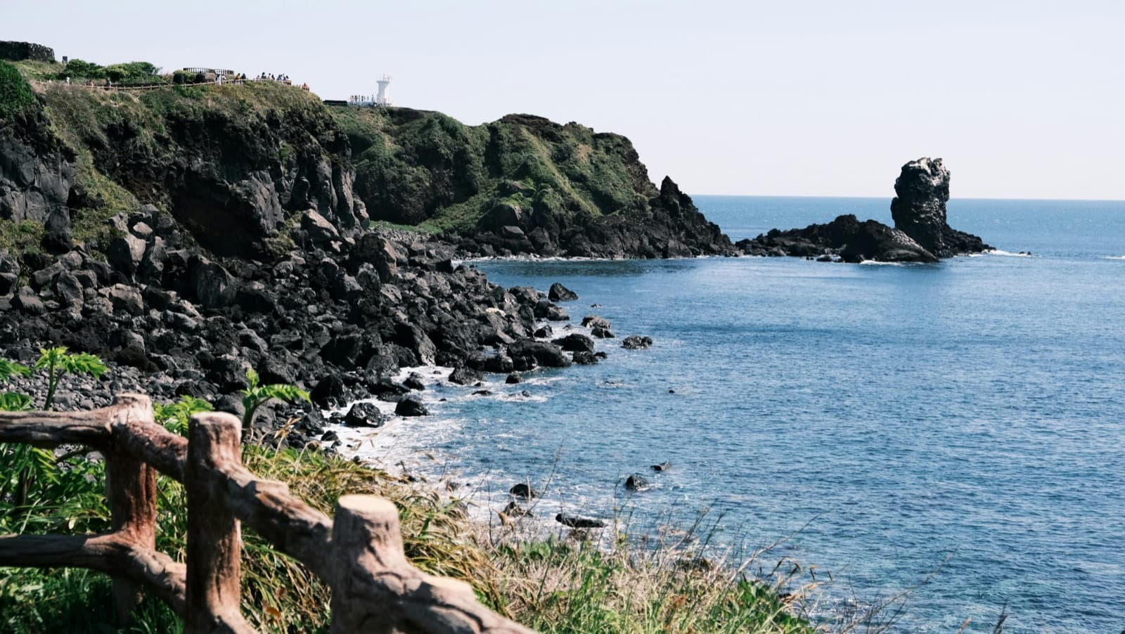 Jeju's east coast Olle trail, basalt cliff path with lighthouse and sea stack