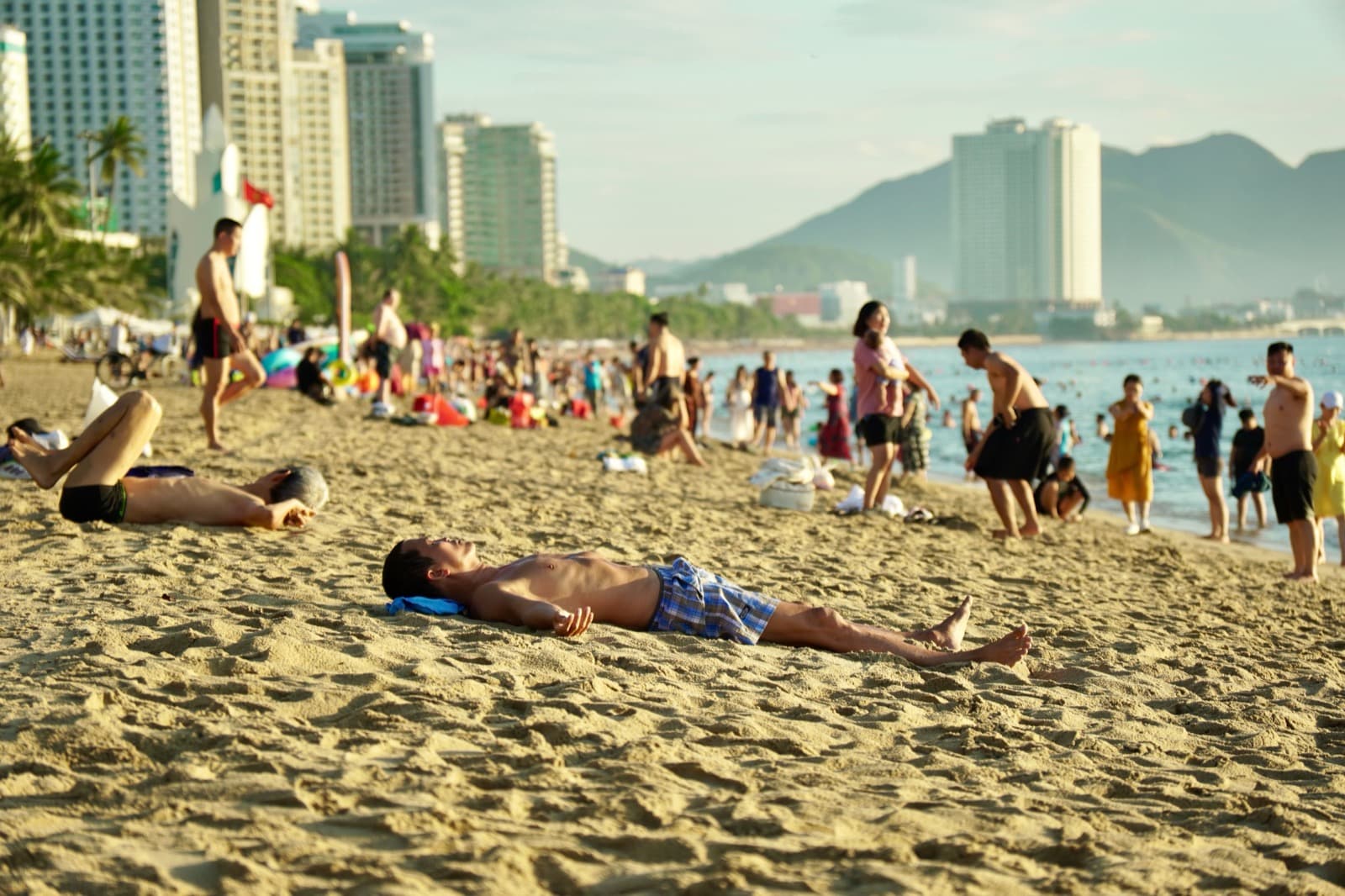 芽庄海滩的白天,遮阳伞与戏水的人们