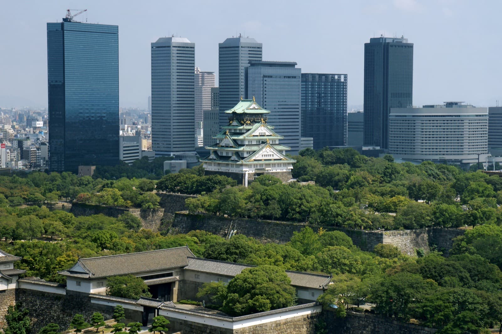 Osaka Castle amid the modern skyline, the keep rises above the moat and park, flanked by glass towers