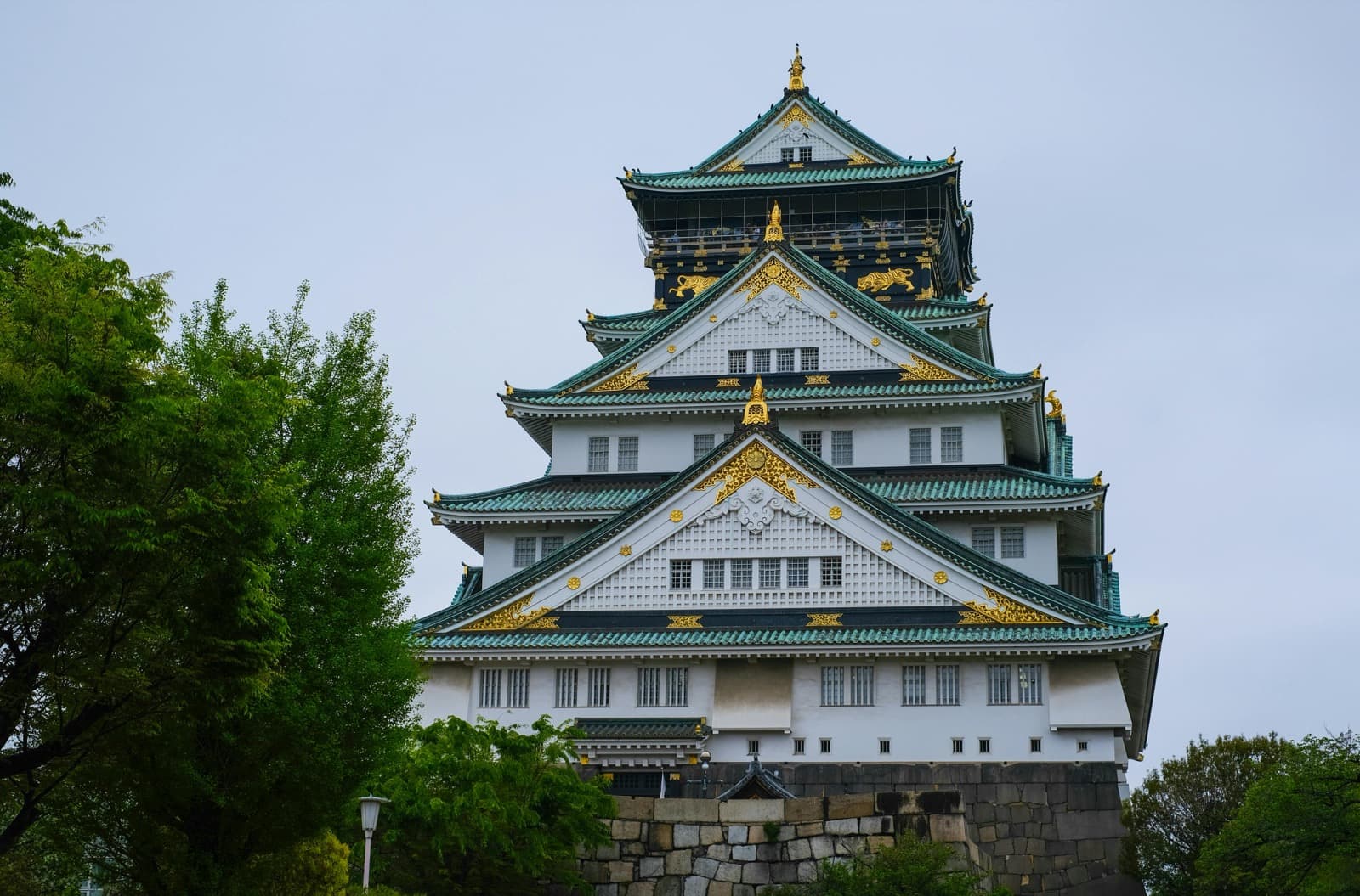 Osaka Castle keep up close, gold-leaf ornaments and green-tiled roof of the 5-floor tower