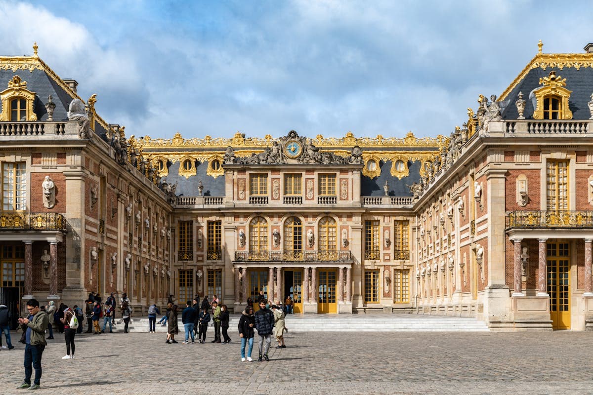 Palace of Versailles, the marble cour d'honneur grand entrance with gilded gates; Louis XIV's ultimate expression of royal power