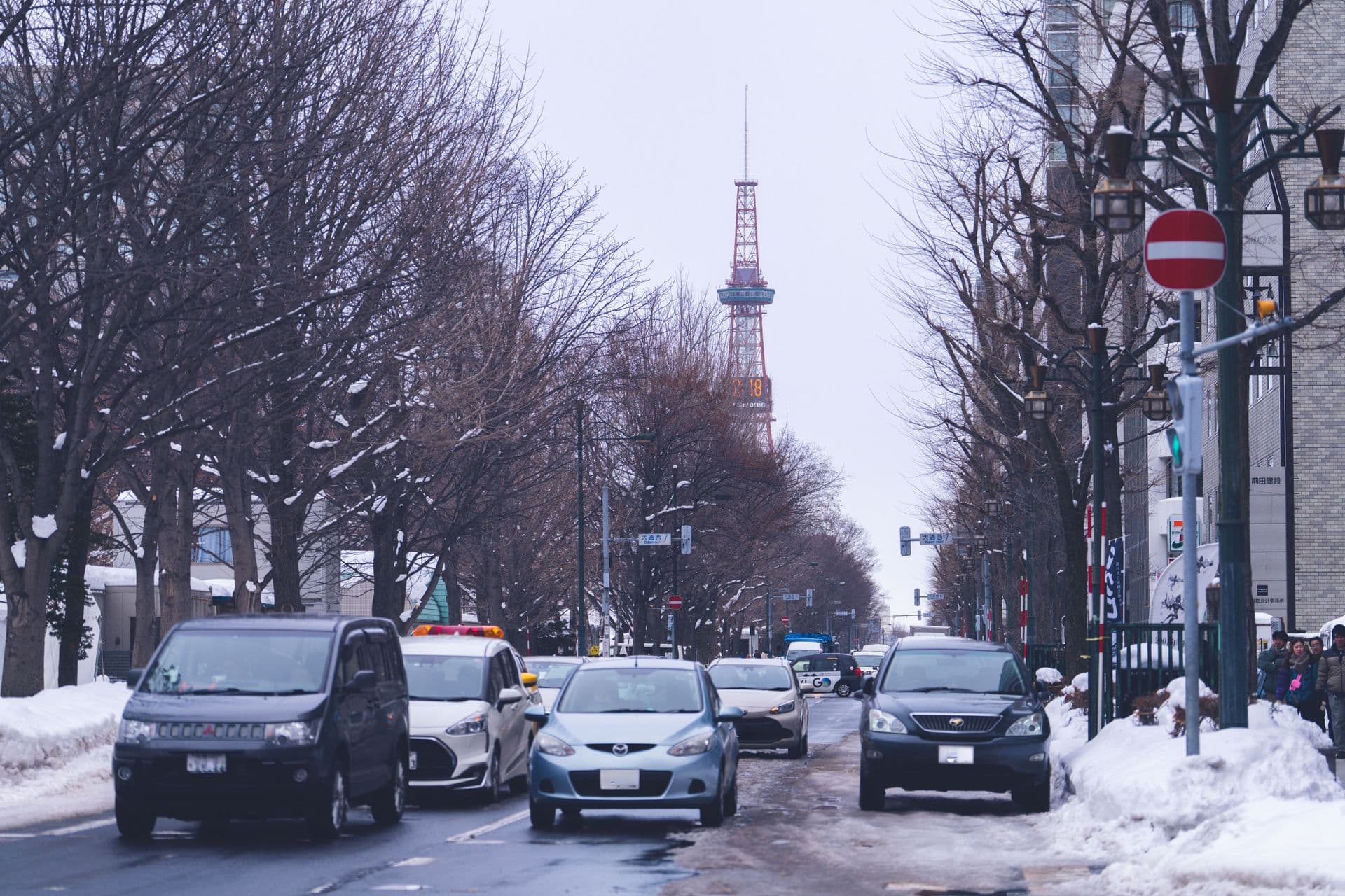 Snow-piled street at Odori Nishi 7 with the Sapporo TV Tower down the boulevard