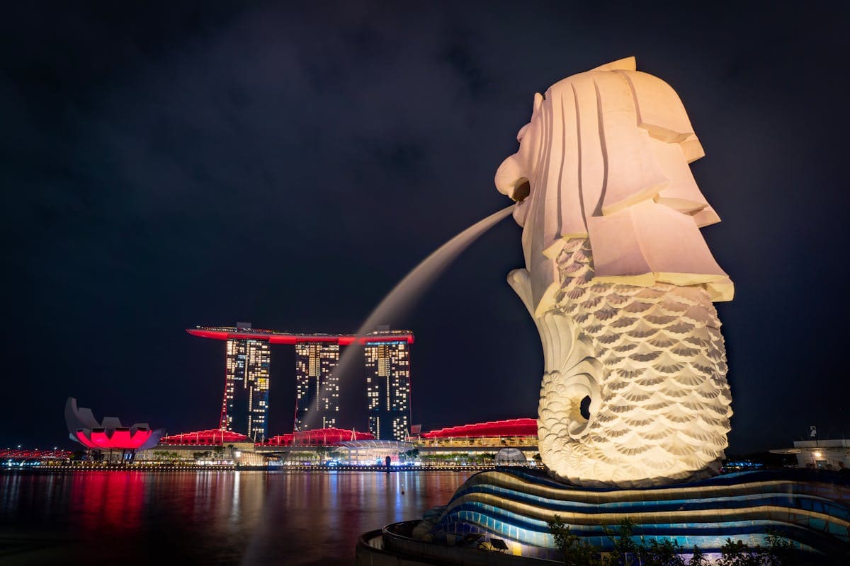 夜晚的鱼尾狮,身后是红光璀璨的滨海湾金沙三塔